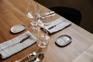 a wooden table with wine glasses and silverware on it at Paragon 700 Boutique Hotel & SPA in Ostuni