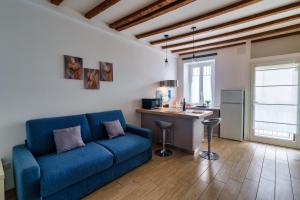 a living room with a blue couch and a kitchen at Duomo in 10 minutes - modern close to Cadorna Station in Milan