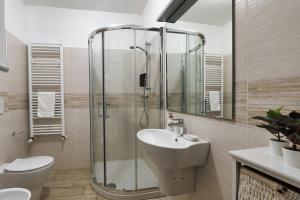 uma casa de banho com um chuveiro, um lavatório e um WC. em Duomo in 10 minutes - modern close to Cadorna Station em Milão
