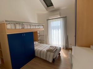 a small bedroom with a bunk bed and a window at Attico Fronte Mare nel Borgo di Celle Ligure in Celle Ligure