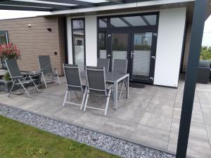 a patio with a table and chairs on it at Ferienhaus / Chalet / Bungalow am See, Holland, Niederlande, Lathum in Lathum