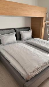 a large bed with two pillows on top of it at AA Apartment in Ventspils