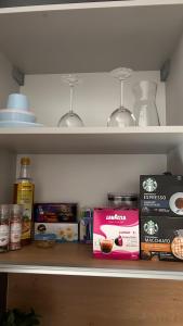 a shelf with food items and wine glasses in a refrigerator at AA Apartment in Ventspils