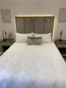 a bedroom with a large white bed with two tables at Newly renovated Stables conversion in Burstwick