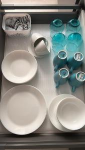 a drawer filled with white plates and bowls and a drawer with at AA Apartment in Ventspils