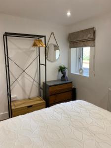 a bedroom with a bed and a mirror and a dresser at Newly renovated Stables conversion in Burstwick
