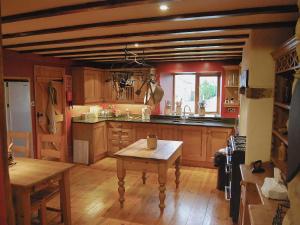 a kitchen with wooden cabinets and a wooden table at Featherstone Cottage in Pickering