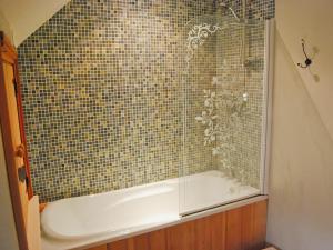 a bathroom with a tub and a tiled shower at Featherstone Cottage in Pickering