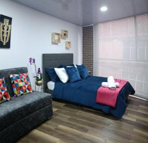 ein Schlafzimmer mit einem blauen Bett und einem Sofa in der Unterkunft Nuevo Loft completo 34 Corferias Movistar Arena Campin HOST-MI in Bogotá