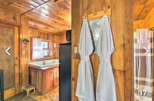 a kitchen with a black refrigerator and a window at Hidden Rest Cabins and Resort in Lake of the Woods