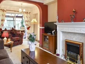 sala de estar con chimenea y TV en North Cottage, en Heighington