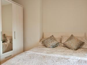a bedroom with a bed with two pillows and a mirror at North Cottage in Heighington
