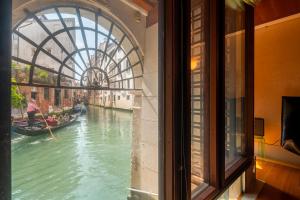 ヴェネツィアにあるCasa Flavia ai Morosini - Luxury apartment with Canal Viewのゴンドラ付きの運河の窓からの眺め