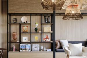 una sala de estar con un estante de libros con artículos. en Fairfield by Marriott Kagoshima Sakurajima, en Tarumizu