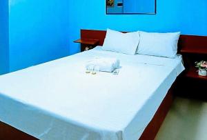 a large white bed with two towels on it at Jeanine's Travellers Inn by RedDoorz in Morong