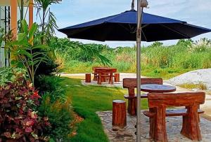 una mesa de picnic y una sombrilla en un patio en Jeanine's Travellers Inn by RedDoorz, en Morong