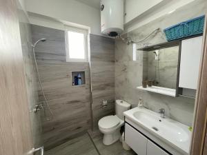 ein Bad mit einem WC, einem Waschbecken und einer Dusche in der Unterkunft Villa Kostian in Sarandë