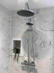 a shower in a bathroom with white marble walls at Newly renovated Stables conversion in Burstwick