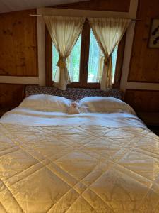 duże białe łóżko w sypialni z oknami w obiekcie Parco delle stelle w mieście Castel del Monte