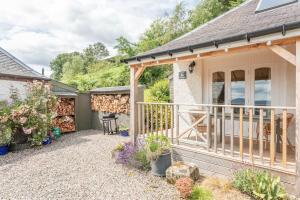 un cottage con terrazza e patio di The Stable - cottage with a spectacular lake view a Port of Menteith