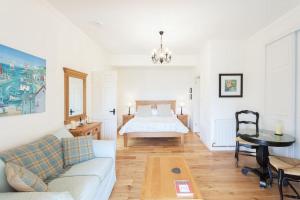 uma sala de estar com uma cama e um sofá em The Stable - cottage with a spectacular lake view em Port of Menteith