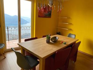 ein Esszimmer mit einem Holztisch und Stühlen in der Unterkunft Inspiration über dem See in Locarno