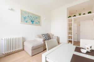 uma sala de estar branca com um sofá e uma cadeira em Milano- Darsena and Navigli Area! Cozy APT! em Milão