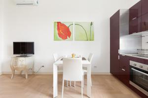 uma cozinha com uma mesa branca e cadeiras brancas em Milano- Darsena and Navigli Area! Cozy APT! em Milão