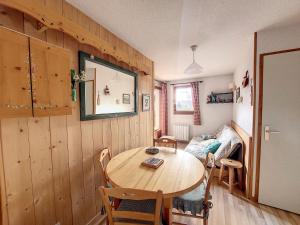 uma sala de jantar com uma mesa de madeira e cadeiras em Appartement 1 chambre avec garage em Praz-sur-Arly