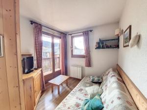 1 dormitorio con 1 cama, TV y ventana en Appartement 1 chambre avec garage, en Praz-sur-Arly