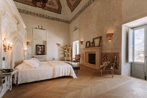 a bedroom with a large bed and a fireplace at Paragon 700 Boutique Hotel & SPA in Ostuni