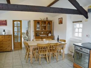 a kitchen with a wooden table and chairs at Colman Bach in Llangwnadl