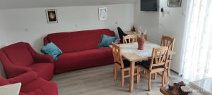 ein Wohnzimmer mit einem roten Sofa und einem Tisch in der Unterkunft LiamMarco in Plaški