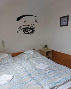 a bedroom with a bed with an eye on the wall at Apartmancentrum in Gyula
