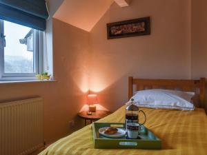 a bedroom with a tray of food on a bed at Sunny Dales Townhouse in Settle