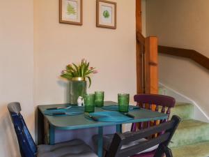 Una mesa con cuatro tazas verdes encima. en Sunny Dales Townhouse en Settle