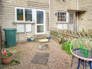 a backyard with a table and chairs and a fence at Sunny Dales Townhouse in Settle
