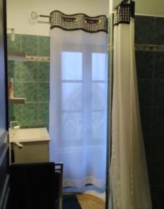 a bathroom with a shower curtain and a sink at L’ Atypique in Leuc