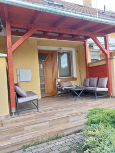 a wooden deck with two chairs and a table at Apartmancentrum in Gyula