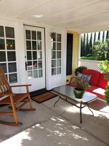 un patio con sofá rojo y mesa de cristal en Bayberry Inn B&B and Oregon Wellness Retreat, en Ashland