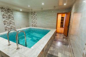 Cette chambre comprend une salle de bains pourvue d'une grande baignoire. dans l'établissement Hotel Avrora, à Omsk