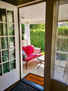 uma sala de estar com um sofá vermelho e uma porta de vidro deslizante em Bayberry Inn B&B and Oregon Wellness Retreat em Ashland