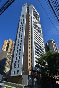 um edifício alto numa rua da cidade com edifícios em Dois quartos, lindo, garagem, Condomínio Clube Sky em Curitiba