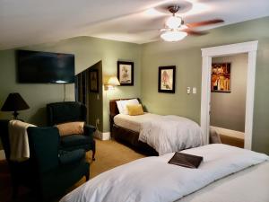 Bayberry Inn B&B and Oregon Wellness Retreat في أشلاند: غرفة فندقية بسريرين وكرسي