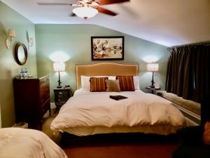 1 dormitorio con 1 cama grande y ventilador de techo en Bayberry Inn B&B and Oregon Wellness Retreat, en Ashland