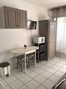 a small kitchen with a table and a stove at Les Rochers de Vallières in Saint-Georges-de-Didonne