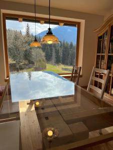 a glass table in a dining room with a large window at Ferienwohnung Remise am Reitl in Fieberbrunn