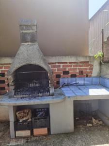 an outdoor pizza oven sitting next to a brick wall at Zelena oaza 300 metara od mora in Banjole