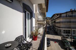 an apartment balcony with a table and chairs and a street at LA CASA DE PROFESOR 1 in Kalabaka