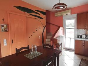 a kitchen with a table and a tree mural on the wall at Lil' fam farm home - Beach 10min in Agios Ioannis